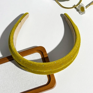 Detail of velvet padded headband in mustard green with subtle silver rhinestone accents