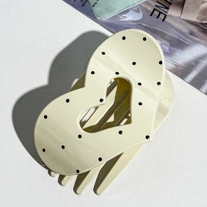 Detail of cream heart hair claw clip with black polka dots and strong resin teeth