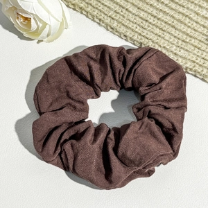 Close-up of brown corduroy scrunchie showing detailed striped velvet texture and fabric