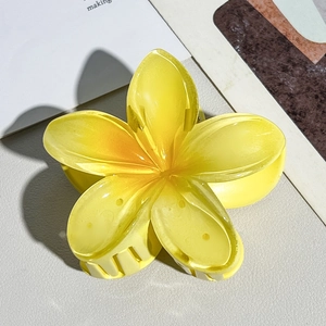 Close-up of a translucent yellow plumeria hair claw clip with detailed resin petals