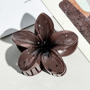 Close-up of translucent dark brown frangipani hair claw clip with smooth resin finish