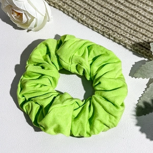 Close-up of fluorescent green oversized scrunchie with ribbed texture and soft knit fabric