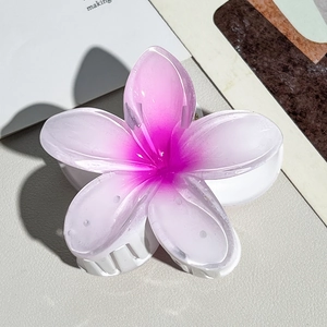 Detailed close-up of a pink gradient plumeria hair claw clip with glossy acetate finish