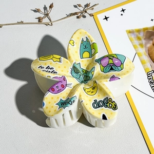 Détail d'une pince à cheveux en fleur avec motifs de chiots mignons et graffitis