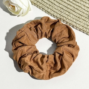Detail of caramel corduroy hair scrunchie showing fine ribbed texture and fabric finish