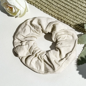Detail of beige corduroy hair scrunchie showing soft ribbed fabric texture and pleats