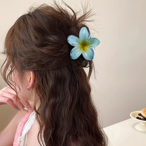 Blue gradient plumeria hair claw clip for beach vacations shown on model hairstyle