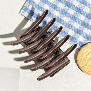 Detail of glossy coffee-colored hair claw clip with strong metal spring for thick hair