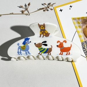 Détail d'une pince à cheveux blanche en acétate avec motifs de chiots mignons imprimés