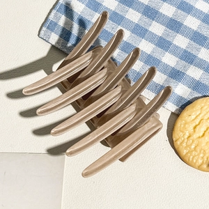 Detailed view of a light brown glossy hair claw clip on a stylish table setting