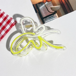 Détail de la pince à cheveux papillon aux accents jaunes et crème sur fond blanc