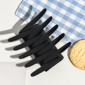 Detail view of large matte black hair claw clip with cross-teeth interlocking design