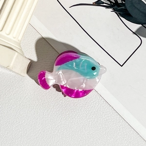 Vue détaillée d'une pince à cheveux poisson colorée en résine de cristal
