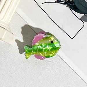Vue détaillée de la pince à cheveux en forme de poisson avec fini dégradé nacre vert rose