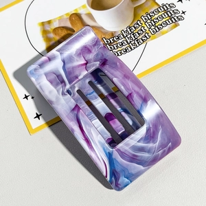Detail of a rectangular marble acetate hair claw clip with purple and blue textures
