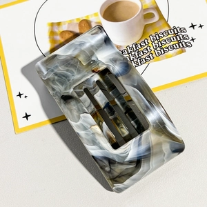 Close-up of marble pattern rectangular hair claw clip on a stylish breakfast table