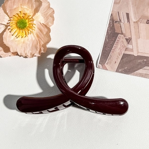 Detail of burgundy claw clip with polished finish and secure tooth structure