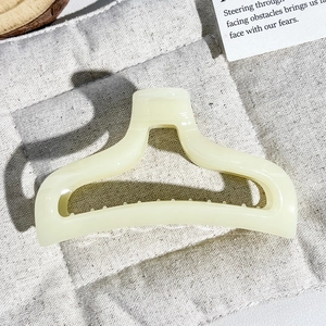 Detailed macro view of the cream-colored matte resin hair claw clip with non-slip teeth