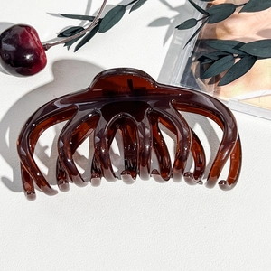 Dettaglio macro della molletta per capelli in resina ambrata lucida per capelli lunghi