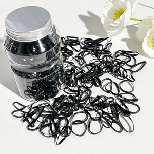 Macro shot of high-elastic black hair bands in a clear plastic jar with screw lid