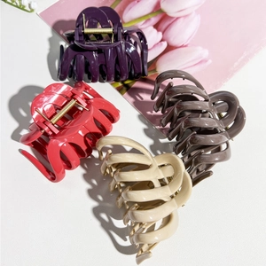 Detail of four colorful pumpkin-shaped hair claw clips with strong gold metal springs