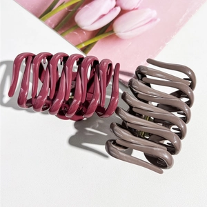 Detail of large wavy hair claw clips in berry red and taupe with strong metal springs