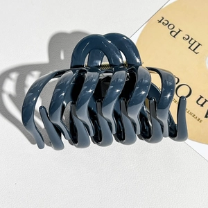 Detail view of the strong gold metal spring on the dark grey-blue large hair claw clip