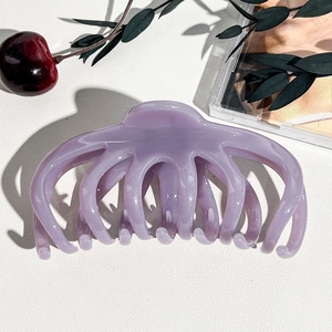 Dettaglio di un fermaglio per capelli lavanda lucido a forma di polpo su fondo bianco