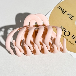 Detail of soft pink large pumpkin hair claw clip showing glossy finish and gold spring