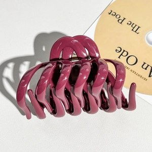 Close-up of a burgundy silicone pumpkin hair claw clip with strong metal spring