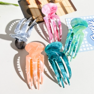 Detailed view of large marble texture acetate hair claws in various elegant colors