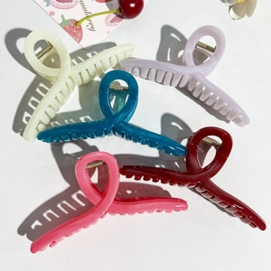 Detailed close-up of colorful PC hair clips with strong metal springs in hard side lighting