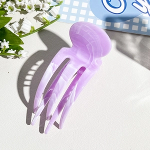 Detail of purple marble hair claw with five-tooth design and elegant glossy texture