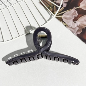 Detailed view of dark grey jelly-textured shark hair claw clip with strong gold metal spring