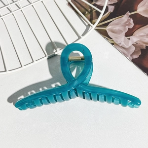 Detail view of large translucent teal hair claw clip showing durable metal spring and teeth