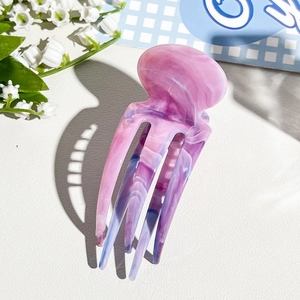 Detail of pink marble cellulose acetate jellyfish hair clip with floral accents