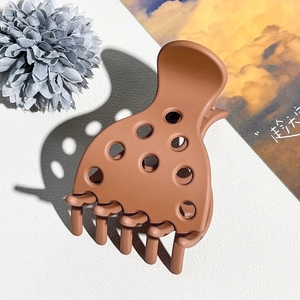 Detailweergave van de karamelbruine matte haarklem met uitgesneden stippen en tanden