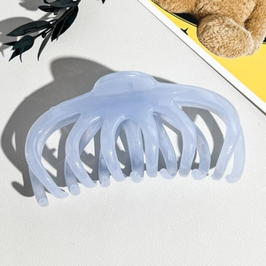 Détail macro de la pince à cheveux bleu clair translucide avec sa structure à dents