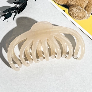 Grosse pince à cheveux en résine crème avec paillettes dorées et design incurvé à dents multiples
