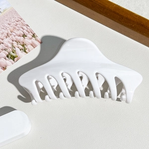 Detailansicht der großen weißen Haarklammer mit glatter Oberfläche und gezahntem Design