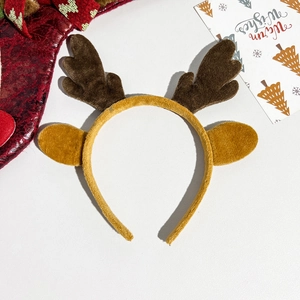 Detail of plush reindeer antler headband with festive Christmas card and red sock