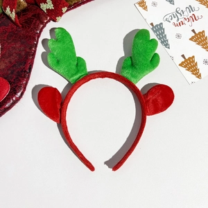 Detail of red and green sequined reindeer antlers headband with festive greeting card