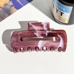 Detailed view of dark burgundy marble hair claw clip with glossy resin texture