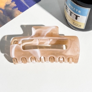 Macro detail of large marble acetate hair claw clip with vintage brown pattern