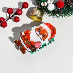 Dettaglio ravvicinato di una pinza per capelli a Babbo Natale su uno sfondo natalizio festoso