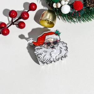Dettaglio di un fermaglio per capelli Babbo Natale con occhiali rosa e finitura perlata