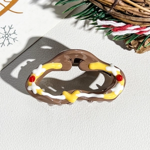 Detail of cute Christmas wavy claw clip with painted heart patterns and festive decorations