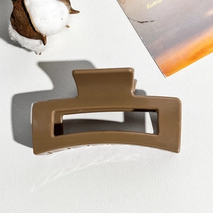 Detailed view of an 8.5cm large matte coffee brown square hair claw clip on a textured surface