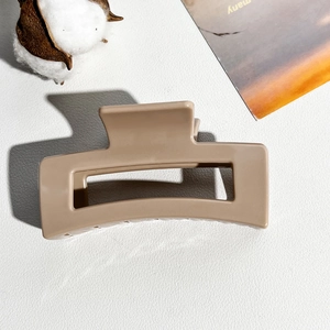 Detail of 8.5cm square matte khaki hair claw with smooth resin frosted finish texture