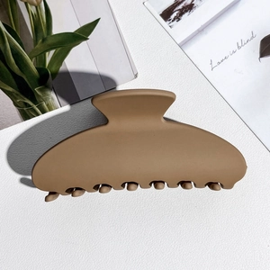 Close-up of a matte khaki brown large hair claw clip on a stylish aesthetic background
